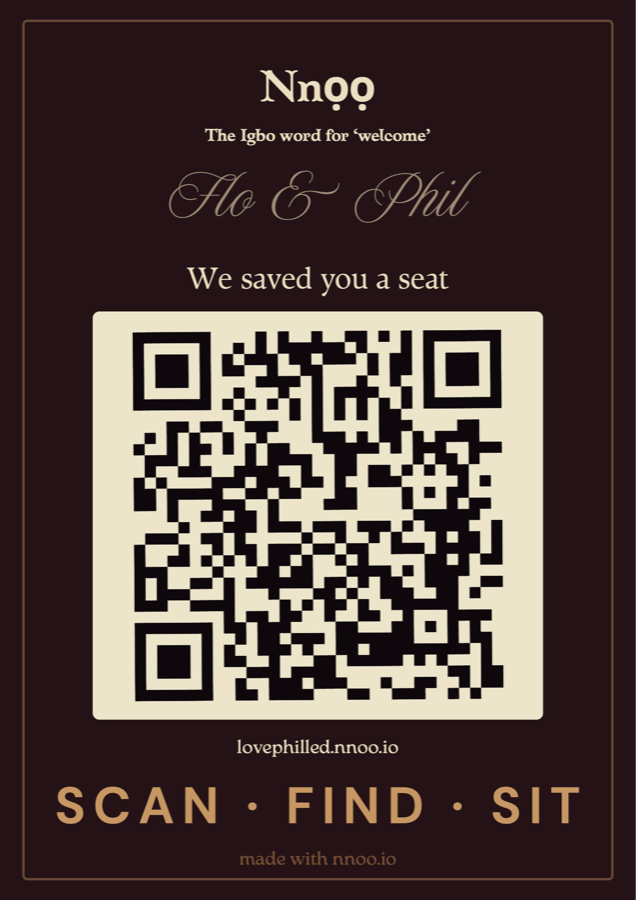 The entrance board: a bordeaux board with a gold keyline, a QR code and the words We saved you a seat.